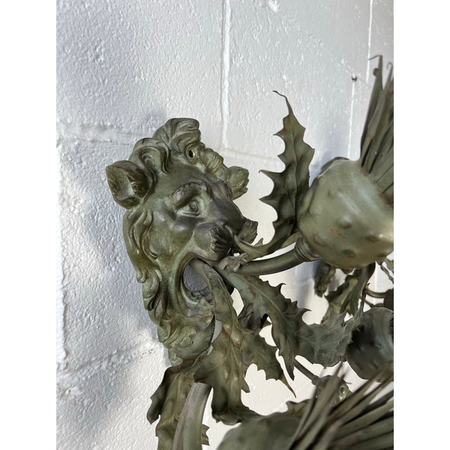 These dramatic three-light wall sconces feature sculptural lion masks framed by exuberant hand-worked foliate elements and...