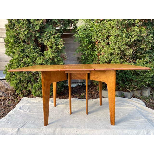 Classic mid-century modern drop leaf dining table, model M166, by Heywood-Wakefield, crafted in solid maple with the...