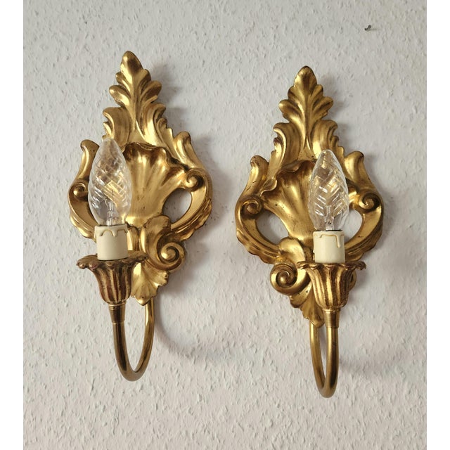 An exceptional pair of elegant antique rocaille wall lamps, gilded wood with a beautiful original patina, hand-carved,...