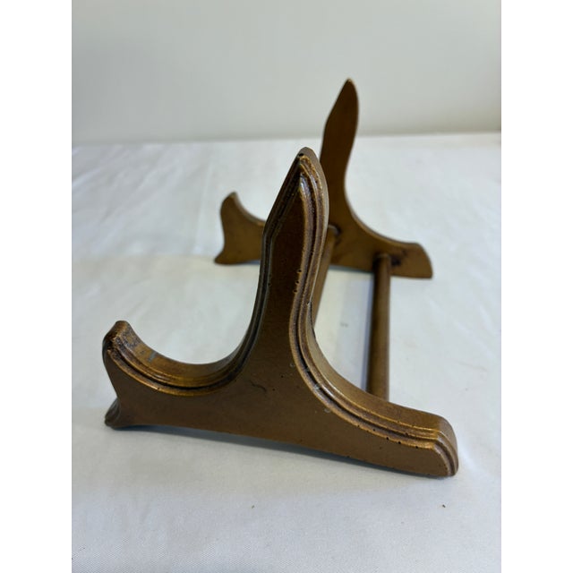 Charming vintage gold painted wood plate stand featuring elegant curved and scrolled details. Ideal for showcasing...