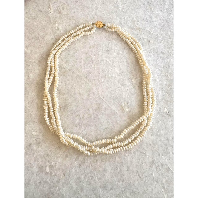 This vintag pearl beaded necklace is made from multiple strands of small, creamy white freshwater pearls that are finely...
