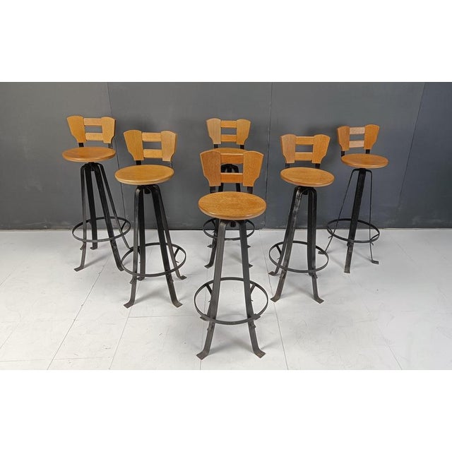 Vintage brutalist bar stools with elegant wrought iron bases and wooden seats and backrests. These bar stools are very...