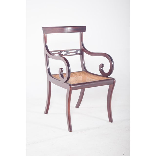 Mahogany chair with straw seat. with curved legs, a slightly arched rear and a saber-shaped front, the arms, also curved,...