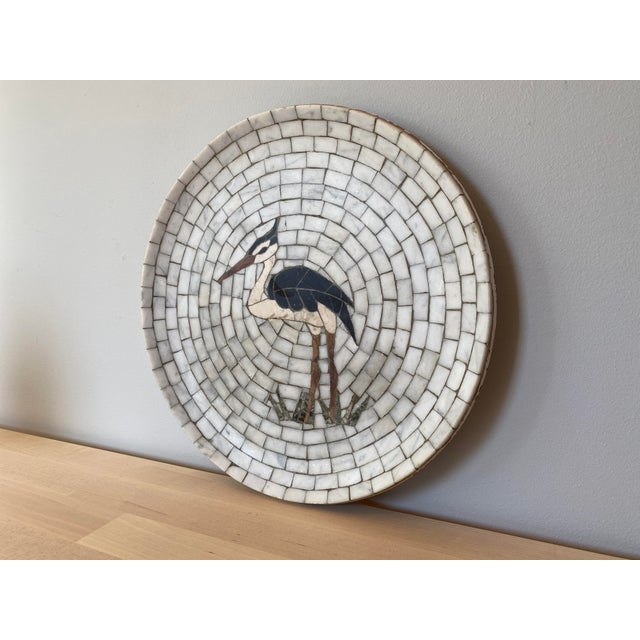 A wonderful midcentury marble mosaic plate featuring a heron motif by Heide Mosaic of Denmark.