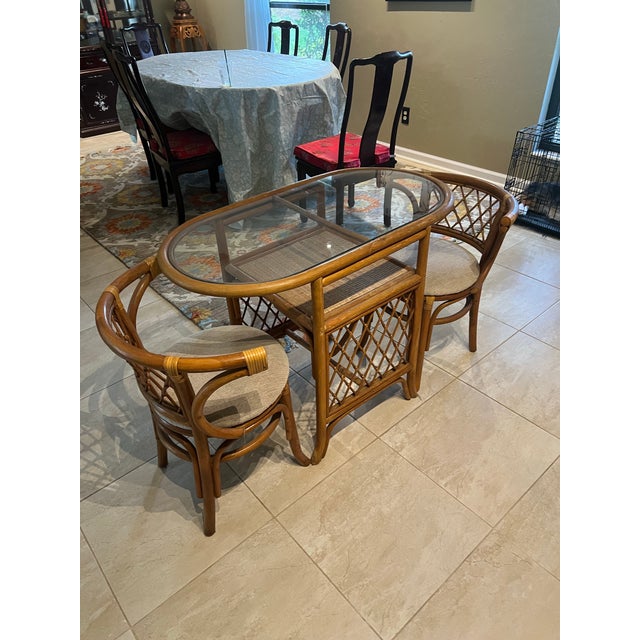 Beautiful vintage rattan/bamboo honeymoon dining set featuring an oval glass-top table and two matching curved armchairs...