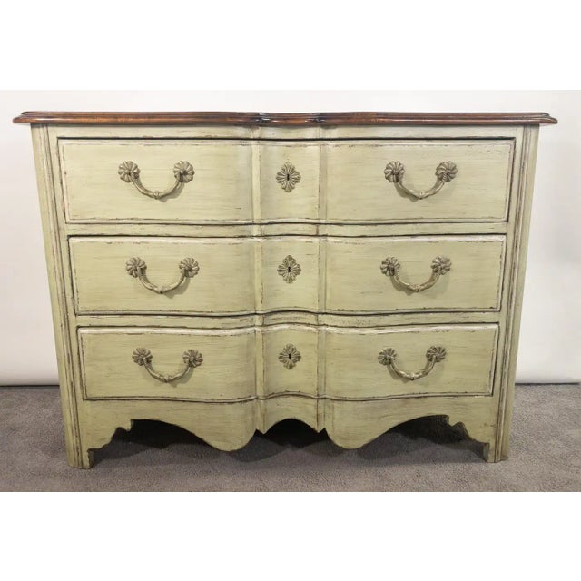 A French provincial style commode or chest having three large drawers. The quality commode is made by Walter E Smith and...
