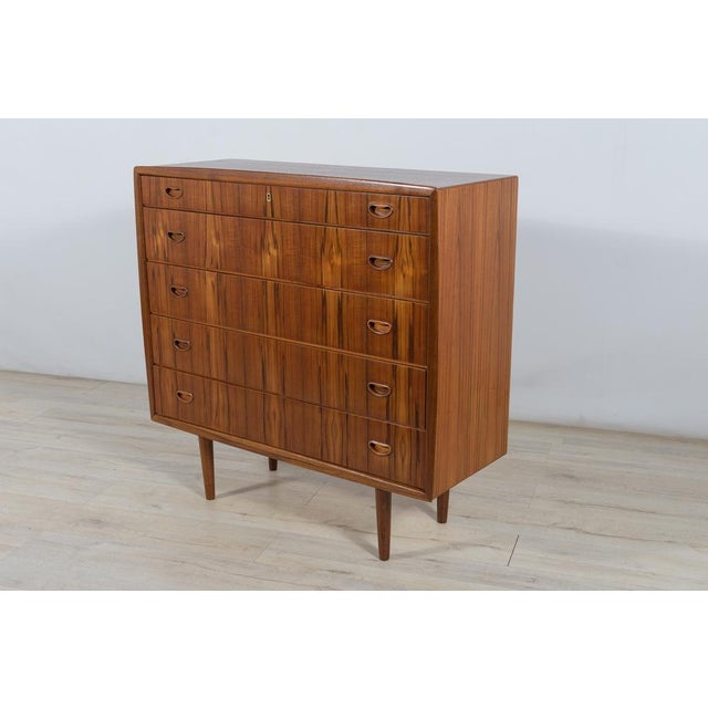 Teak dresser with five drawers, produced in the 1960s in Denmark. There is a fold-out mirror in the third drawer. A chest...