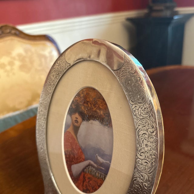 Antique Sterling Silver oval footed picture frame with hand chased foliate design, the top with a blank reserve that you...