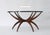 Stunning mid century coffee table with folding wooden spider legs and a 36" diameter round glass top. Legs have brass...
