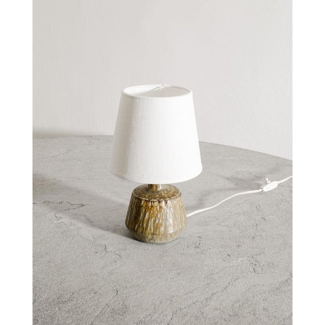 Rare Swedish mid century decorative ceramic table lamp in brown golden glaze from the series "Rubus" designed by Gunnar...