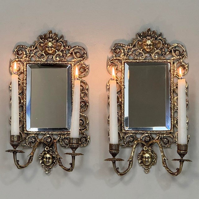 Pair of 19th Century Italian Renaissance Cast Bronze Mirrored Wall Sconces recall the days before electric lighting, when...