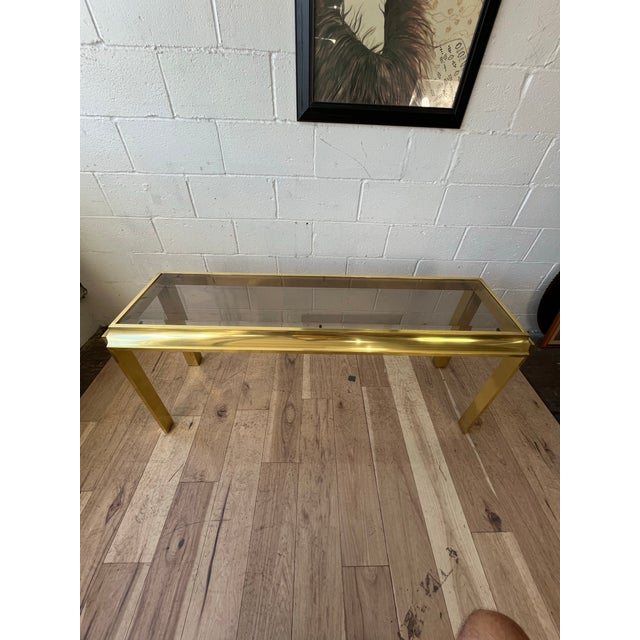 Striking vintage 1970s console table featuring a sculptural brass-tone metal frame, believed to be anodized aluminum,...