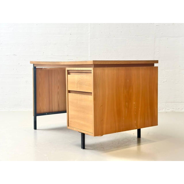 A compact mid-century modern desk, swiss-made by merz roller in the 1960s. The tabletop features a greenish linoleum...