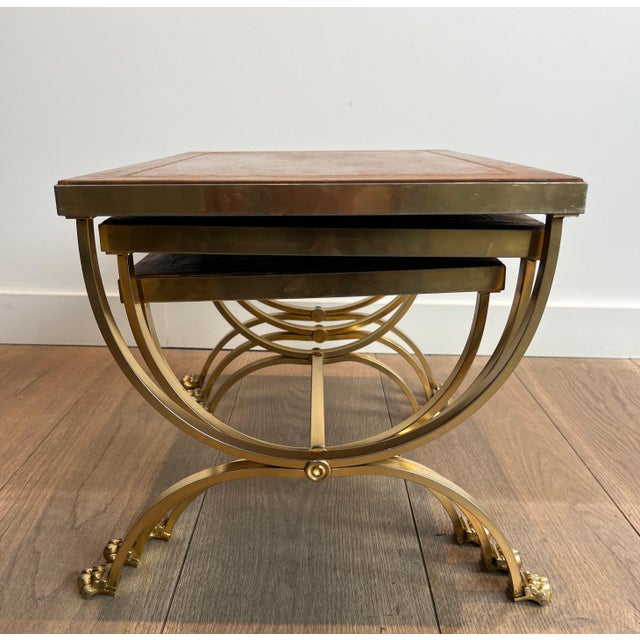 This rare and very beautiful set of nesting tables is in gilded metal with claw feet and brown leather tops. This is a...