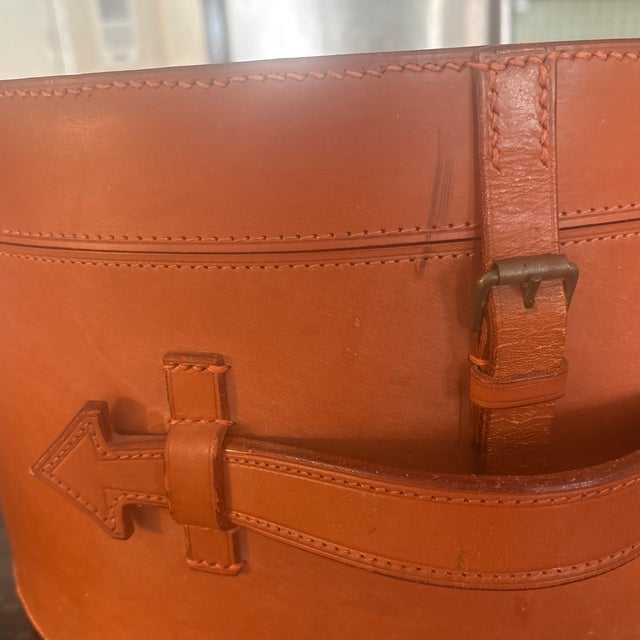 A leather containers with a single working strap, beautifully lined in a deep red fabric. Old world style. 17 inches wide...