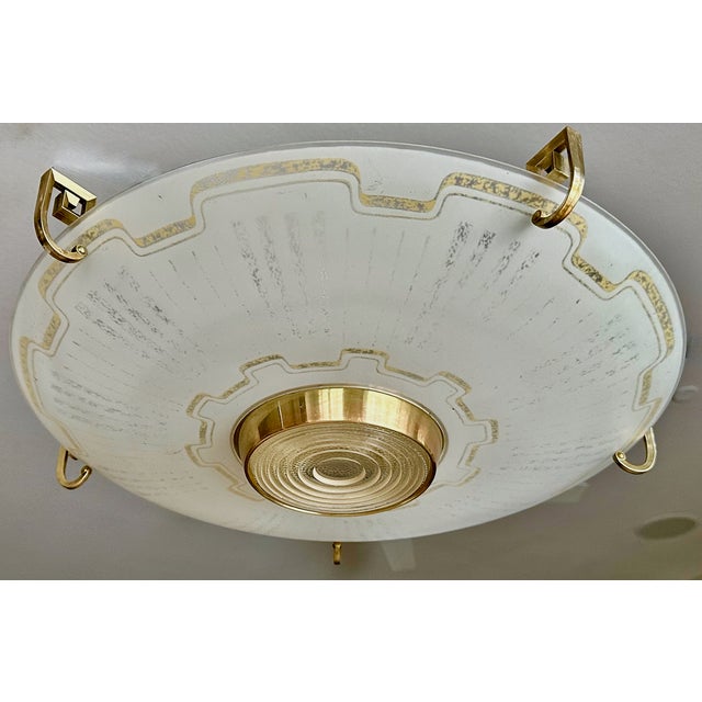 A large Lightolier flying saucer ceiling flush mount ceiling light, with brass Greek key mounts and enameled curved glass...