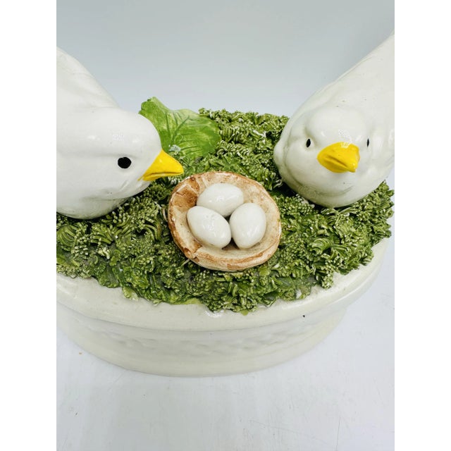 This is a charming two-part Italian ceramic bowl or trinket box with a nature-inspired design. The lid features two white...