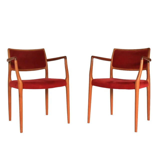 Pair of model 65 teakwood dining chairs by J. L. Moller with red suede upholstery. Some wear to upholstery and minor wear...