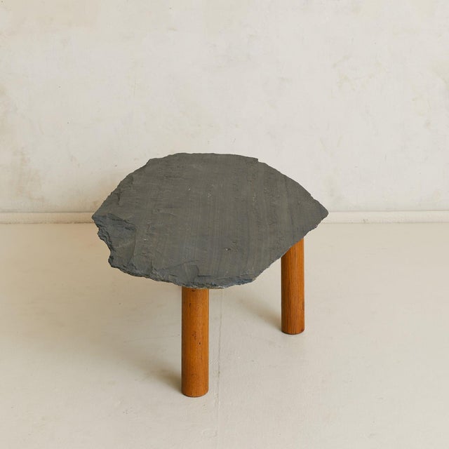 A French coffee table from the mid-20th century, balancing raw slate with the warmth of wood. The irregular top is left...