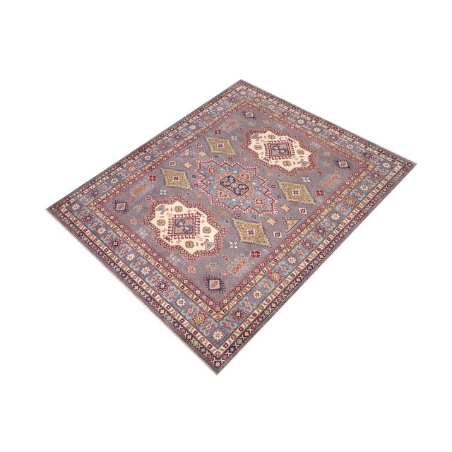Enhance your home with this exquisite hand-knotted Kazak rug, crafted from fine hand-spun wool and dyed with all-natural...