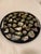 A stunning vintage round black lacquer tray inlaid with dozens of natural abalone shell pieces, each one catching light...
