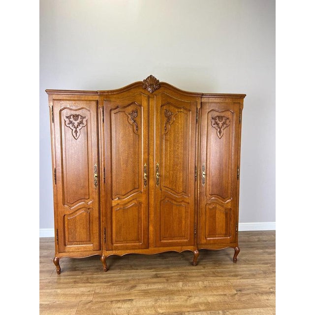 An elegant Vintage French Louis wardrobe crafted in Oak , featuring a substantial four-door design with beautifully shaped...