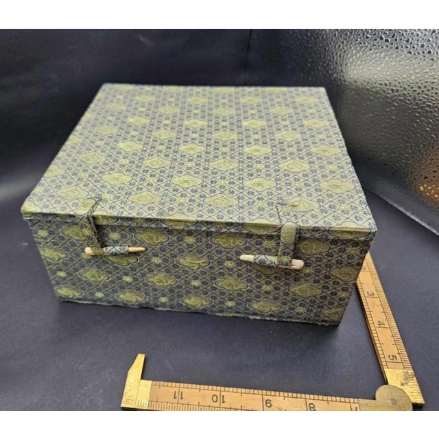 This marvelous vintage 1980s Chinese storage or jewelry box is created in gorgeous gray and blue brocade silk with the...