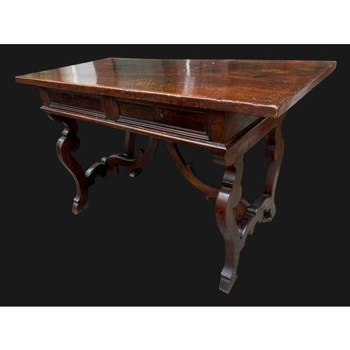Important central walnut desk with an exceptional patina. The piece of furniture has two drawers and is characterized by a...