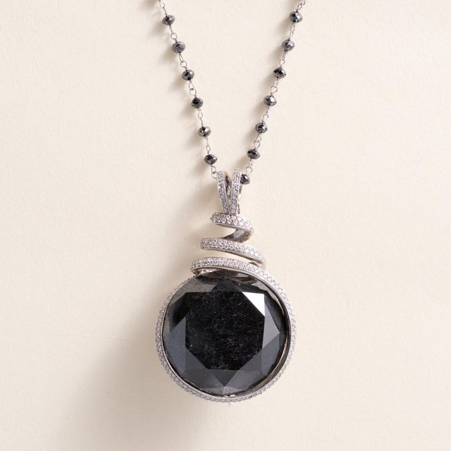 This stunning and unique estate piece showcases a dramatic natural black diamond centerpiece accented by a flowing white...
