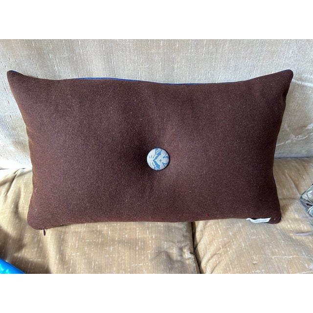 A pillow made with Fortuny border print fabric, backed and accented with wool cashmere, a down insert is included