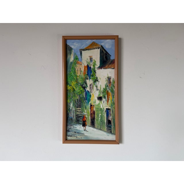A vibrant vintage Impressionist oil on canvas depicting a charming European street scene with colorful, lush greenery, and...