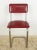 Mid Century style dining chairs featuring a red vinyl seat and back rest, and a steel tube frame. Good condition with...