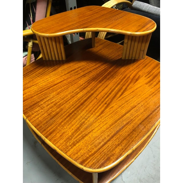 The restored rattan corner table with a striking dimensional quartered koa wood top is a fusion of elegance and natural...