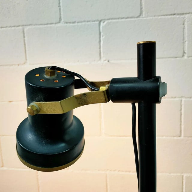 Floor lamp made of black lacquered steel, with two spotlights adjustable in height and direction, two independent switches...