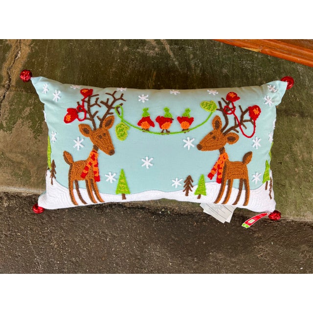 Christmas pillow with reindeers. Measures 12” x 21”. Has red bells on the corners. Great item for Christmas decor.