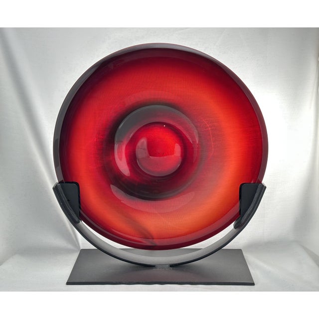 This striking garnet art glass sculpture, perched on a custom black metal stand, is an exquisite example of artisan...