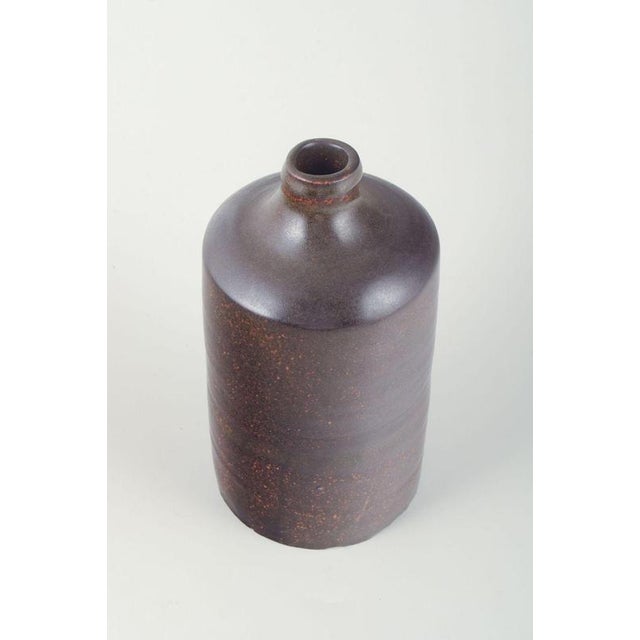 European Studio Potter. Tall cylindrical ceramic vase with a short slightly narrowed neck. The glaze is executed in a deep...