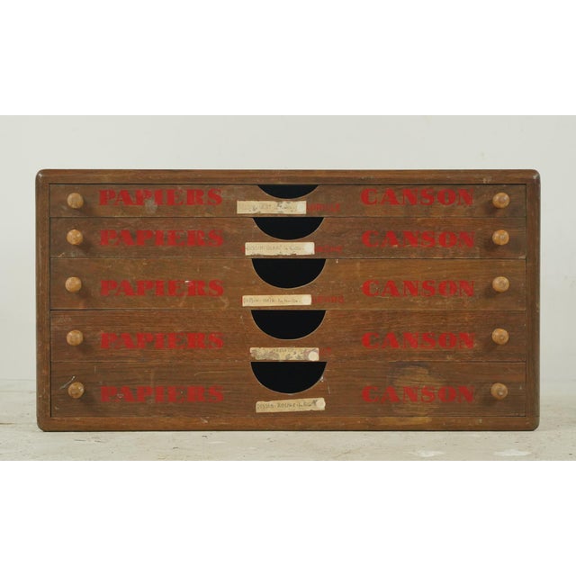 Vintage European paper storage cabinet made of dark stained oak with matching wood knobs on the five drawers. The drawers...
