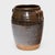 This antique Chinese jar from the early 20th century is cloaked inside and out with a glassy brown glaze that sheets down...