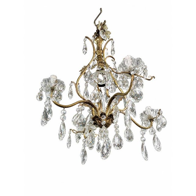 A refined three-light chandelier in gilded bronze, embellished with a rich cascade of cut crystal pendants that provide...