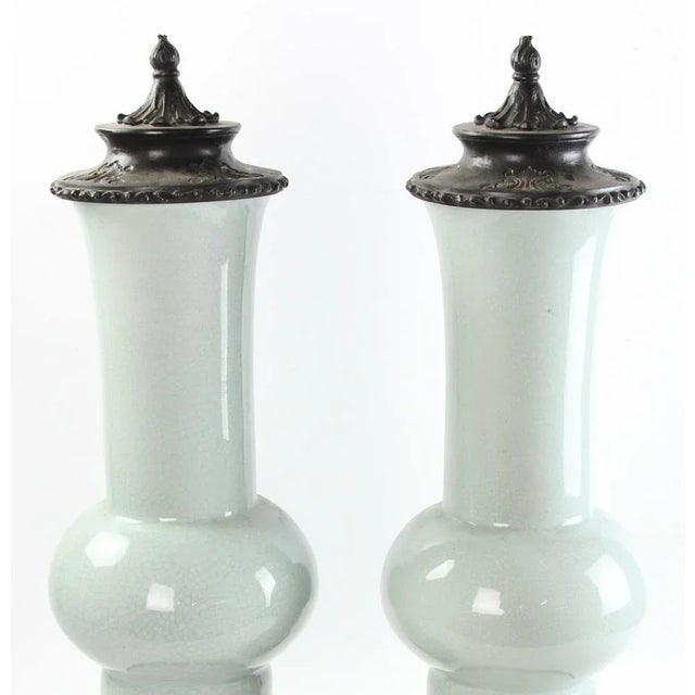 Pair of Chinese gu form celadon vases with metal covers and stands. Measuring 24" height x 8" diameter.