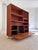 This Danish bookcase is a unique design object that blends the warmth of classic mid-century style with a modern, urban...
