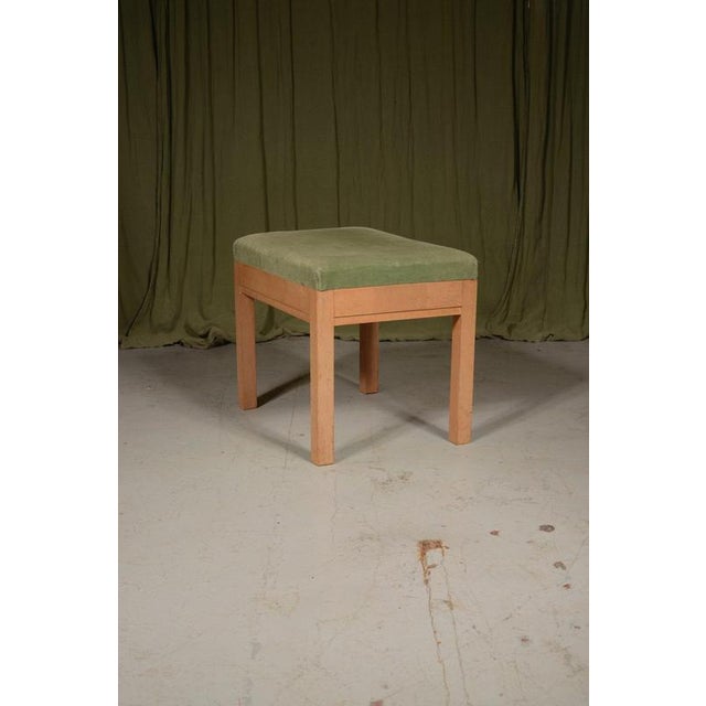 A stylish quarter sawn pale oak stool with a green upholstered top, made in the style of the Heal’s ‘Russett’ range....
