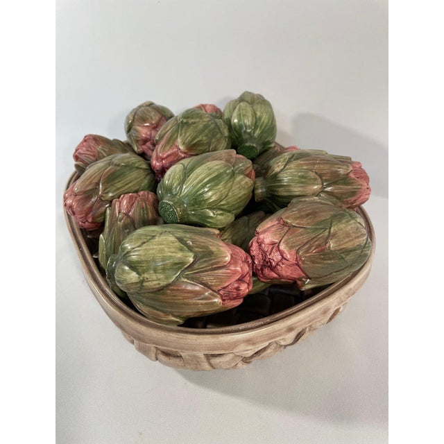 A delightful and realistic Italian ceramic majolica arrangement of artichokes resting in a ceramic market basket. Circa...