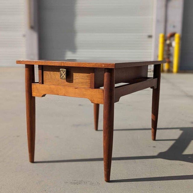 Mid-Century Modern solid wood side table by Red Lion Table Co., featuring a warm wood finish, tapered legs, a single...