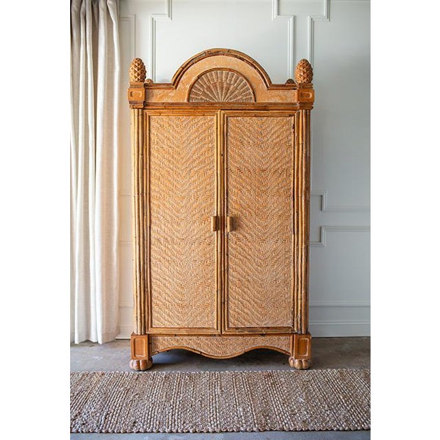 Presenting a 1970s Large Rattan Etched Wood Safari Arch Armoire Wardrobe Storage Cabinet. A striking piece that blends...