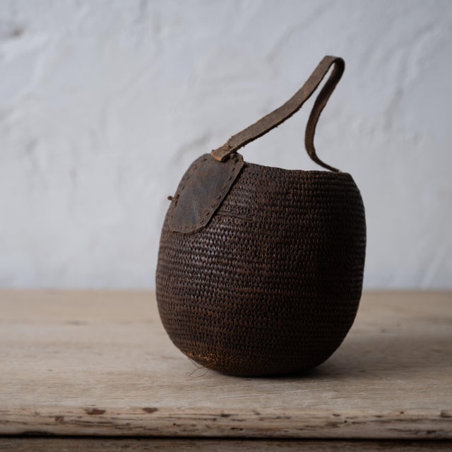 A Kenyan water basket attributed to the Dorobo, circa 1900. 5 by 5 by 5 inches; 7 ½ inches tall with handle