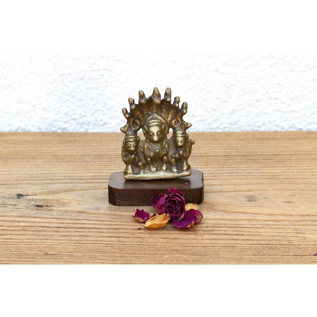 A masterfully cast micro-scale devotional shrine grouping featuring a central deity flanked by attendants beneath a multi-...