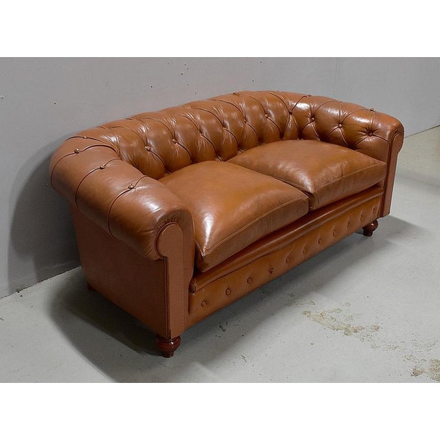 Chesterfield sofa with leather upholstery in Marron Fauve, upholstered on the backrest, armrests and base rail. It offers...
