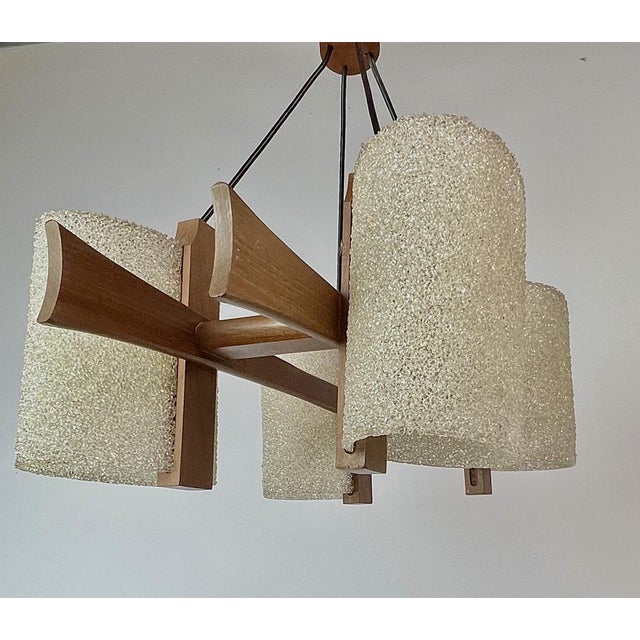 Scandinavian style pendant lamp in teak wood with granite acrylic lampshades. It hangs from four black wires and is...